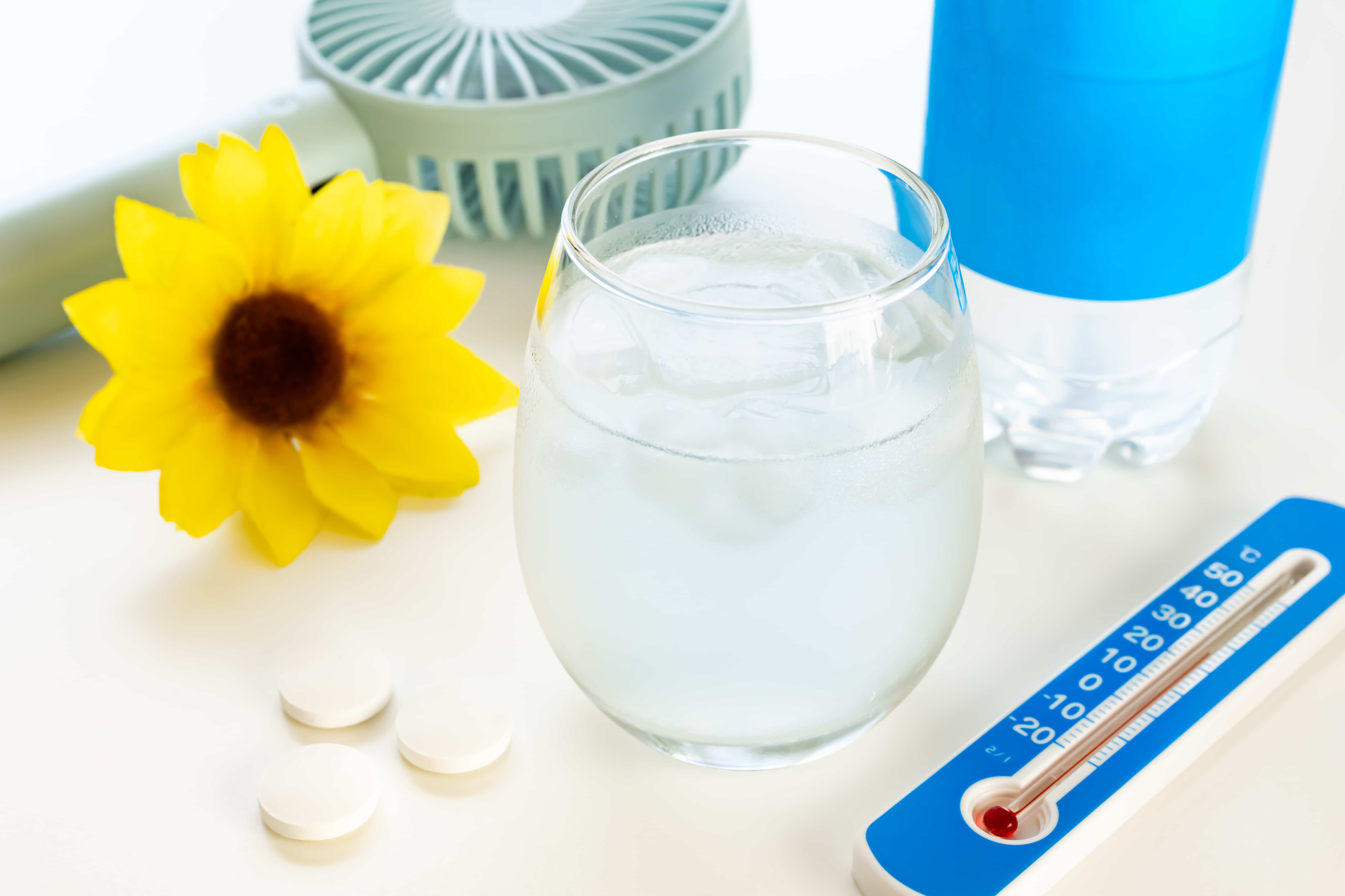 Various ways to stay cool in Japan: sports drinks, a fan, and a hat.