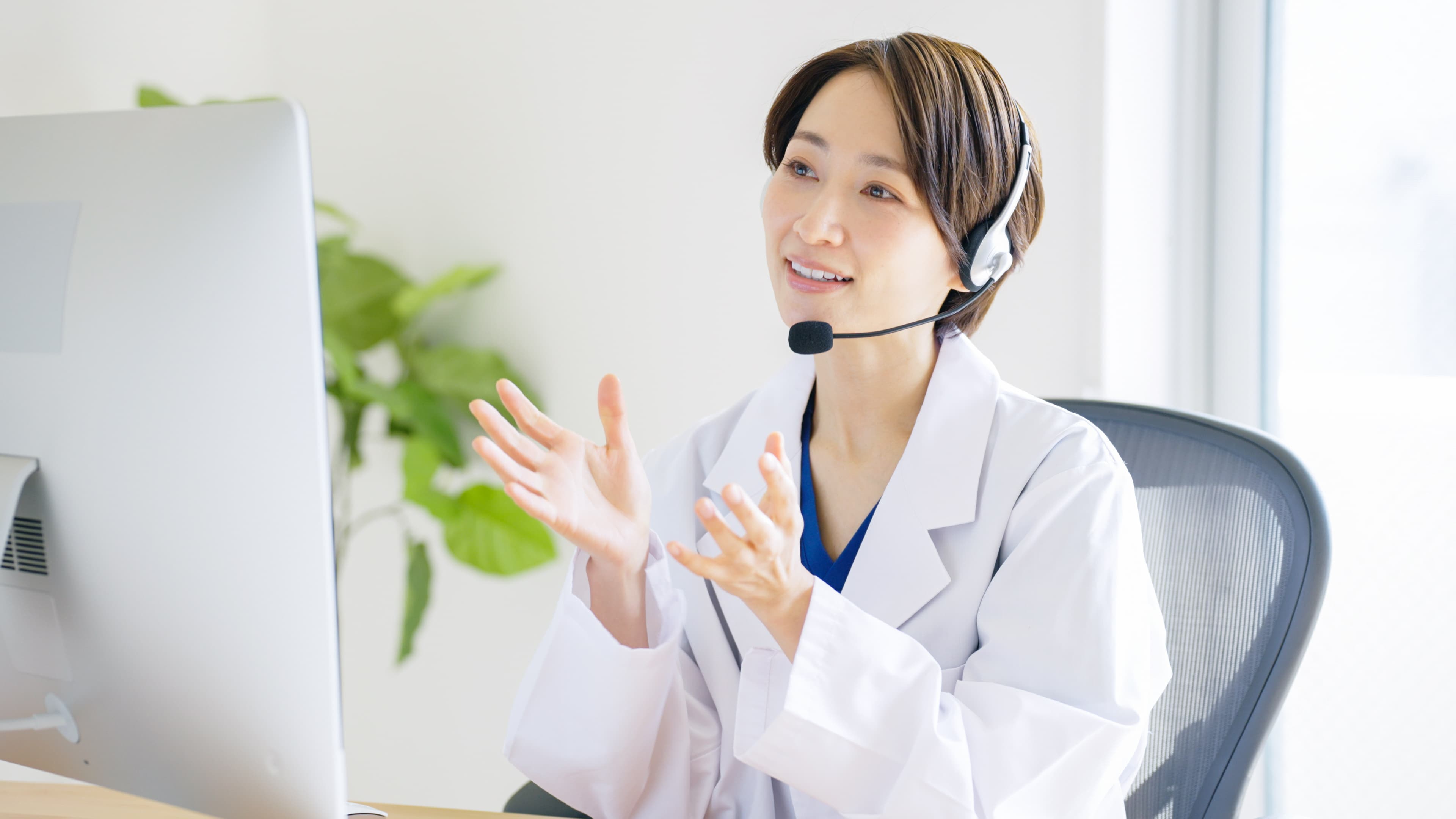 Japanese female doctor with headset providing telemedicine consultation online